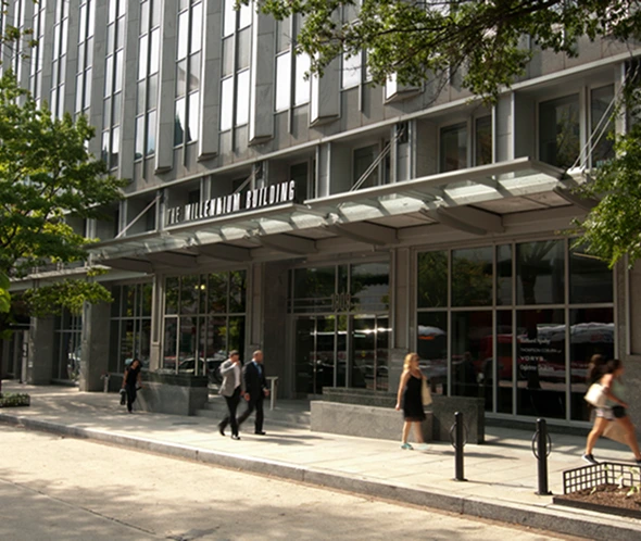 exterior street level view of The Millennium Building with people on the sidewalk in front of the building