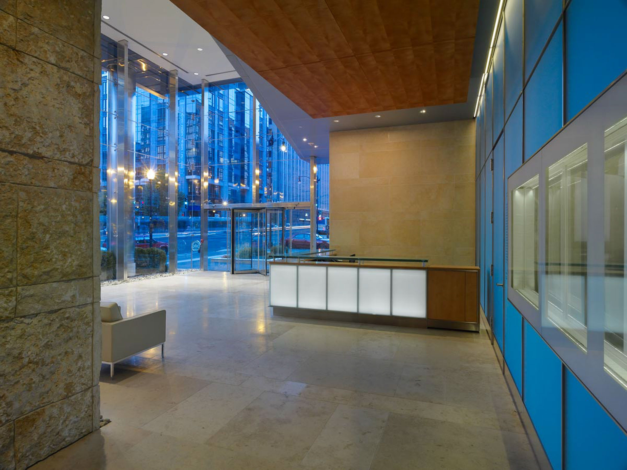 building lobby hallway with front desk and entrance in the background
