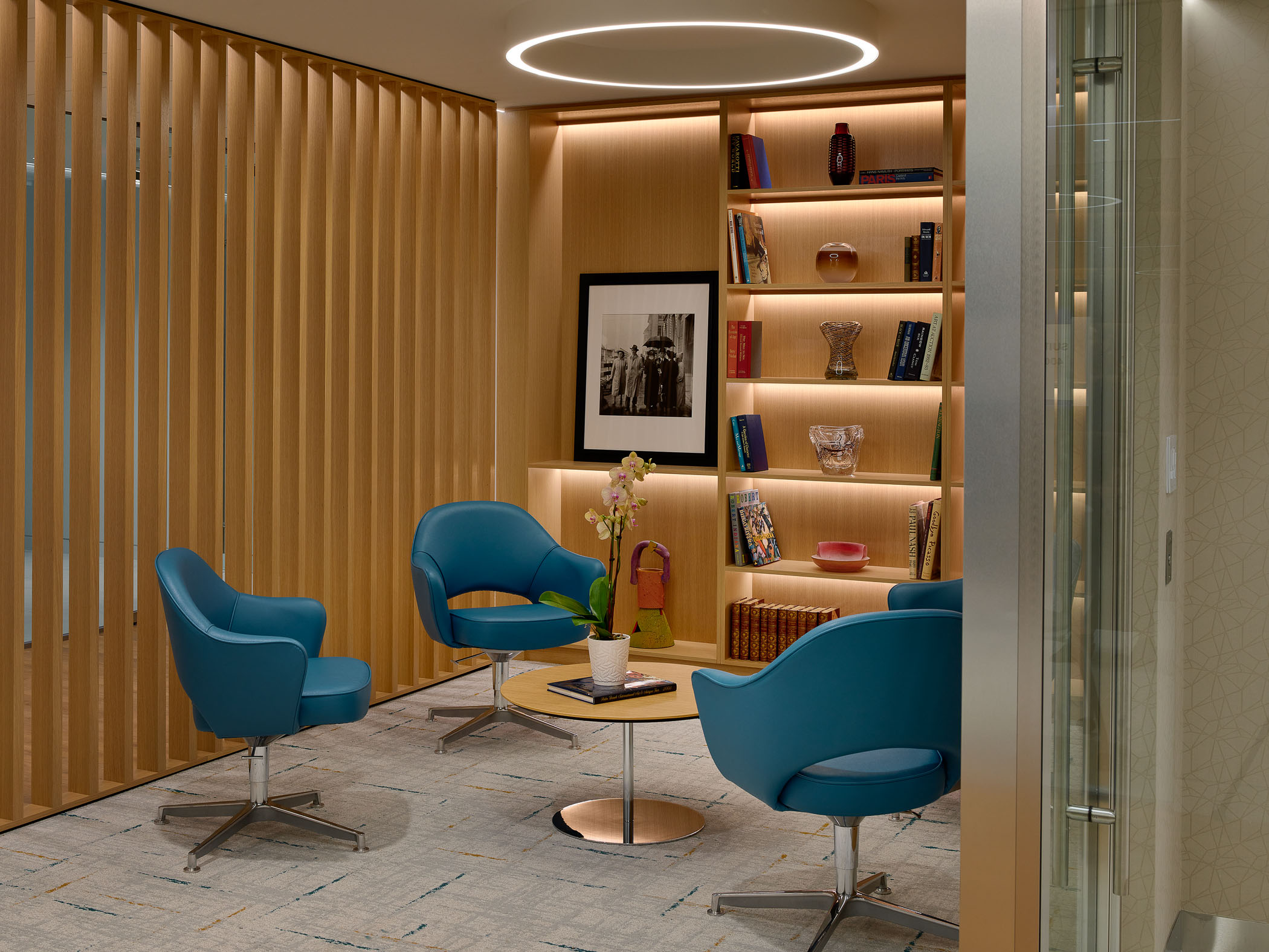 four blue armchairs around a round table in an office building lounge