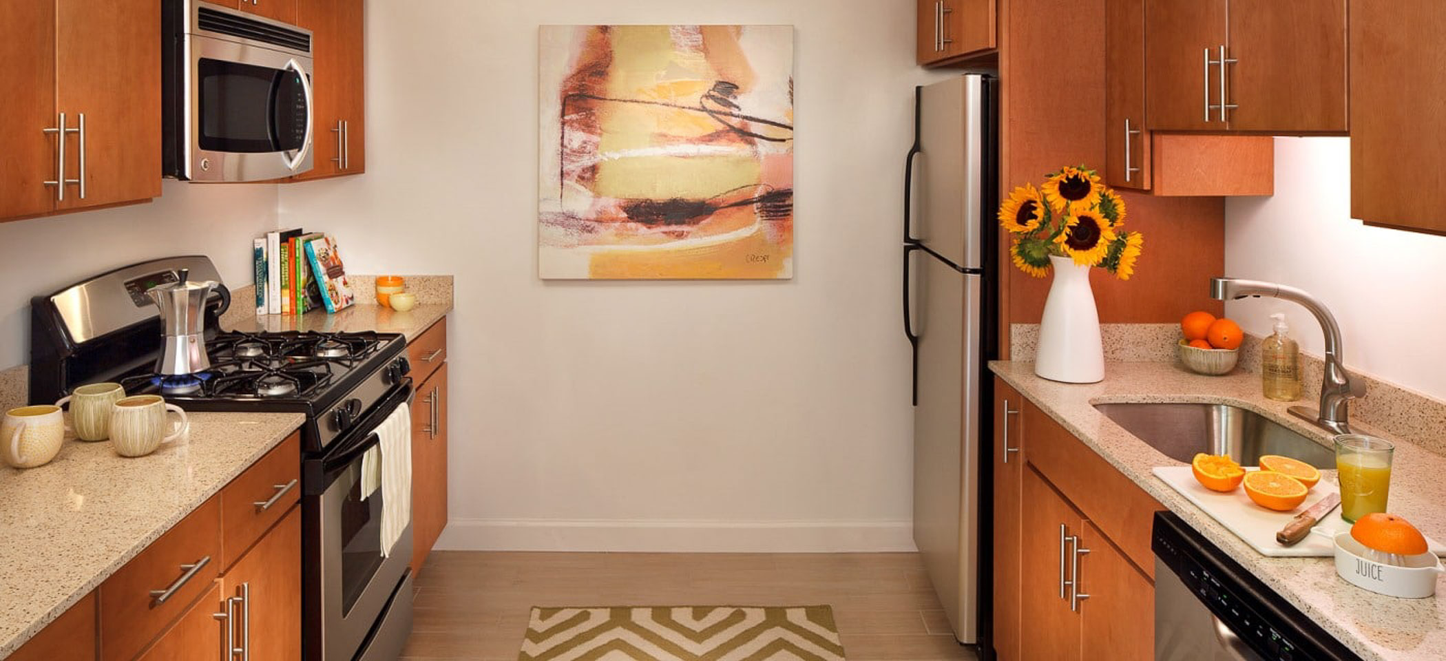 apartment kitchen with sunflowers and oranges on the counter