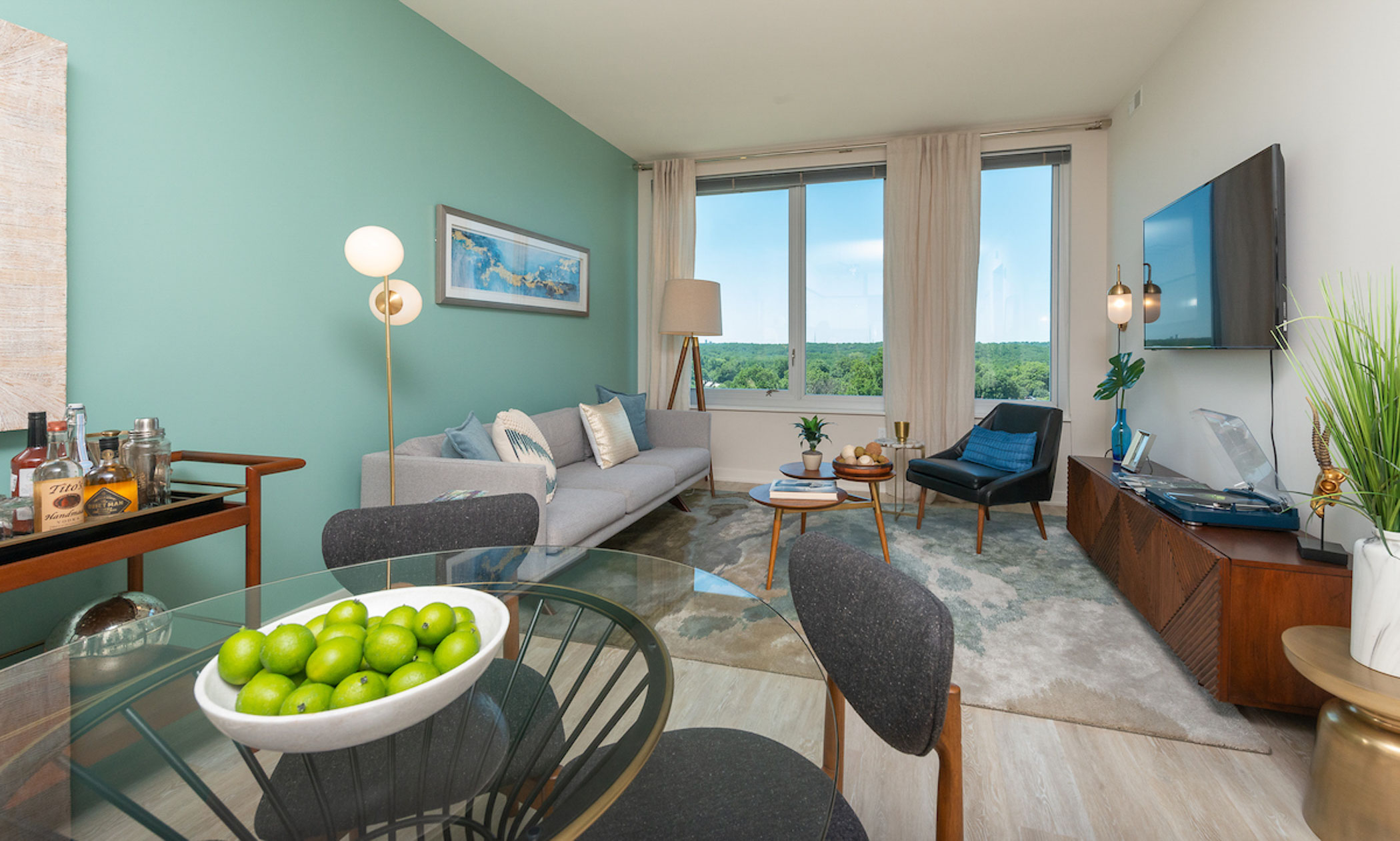 apartment interior with dining table, bar cart and living room in the background