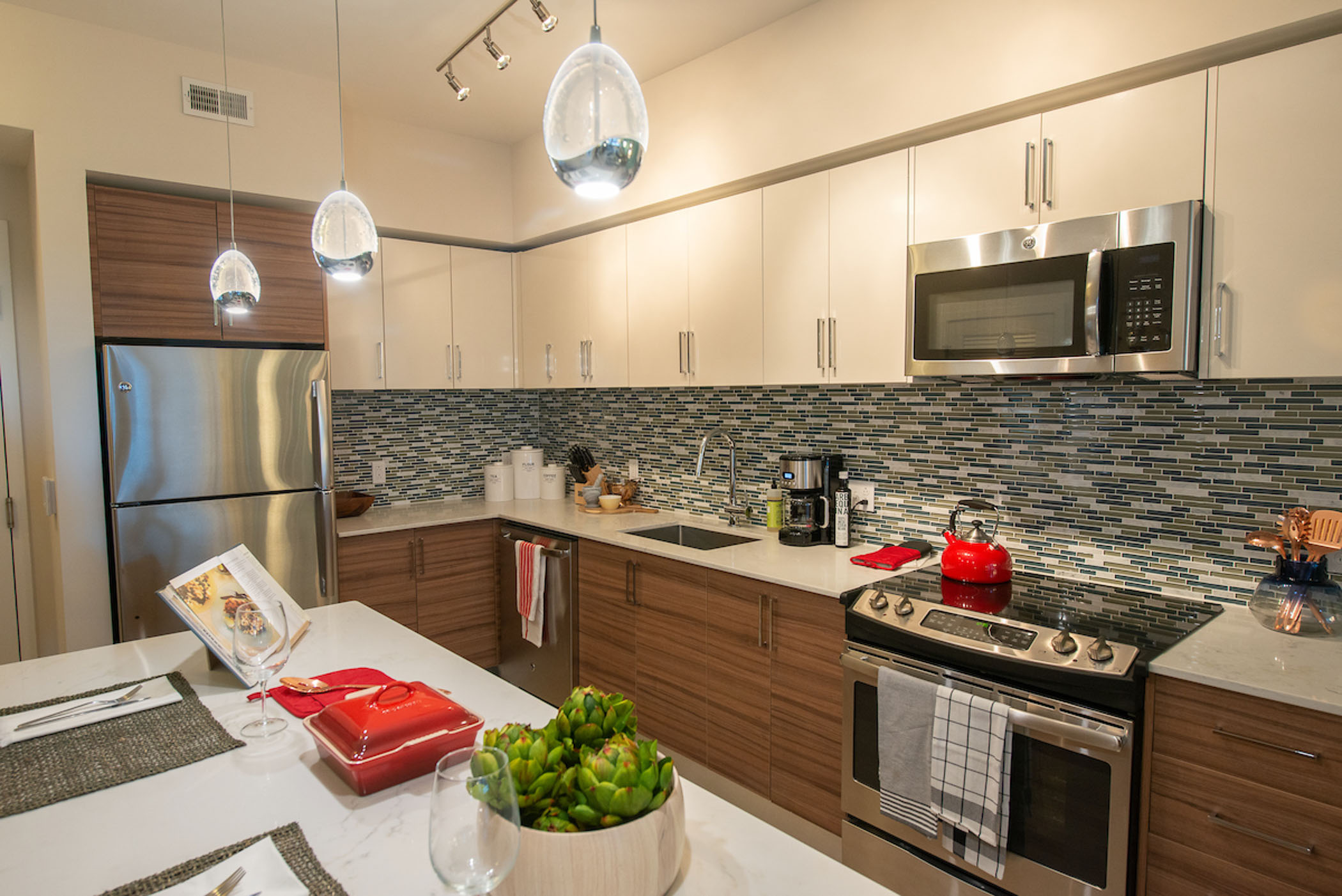 apartment kitchen with white upper cabinets and brown lower cabinets