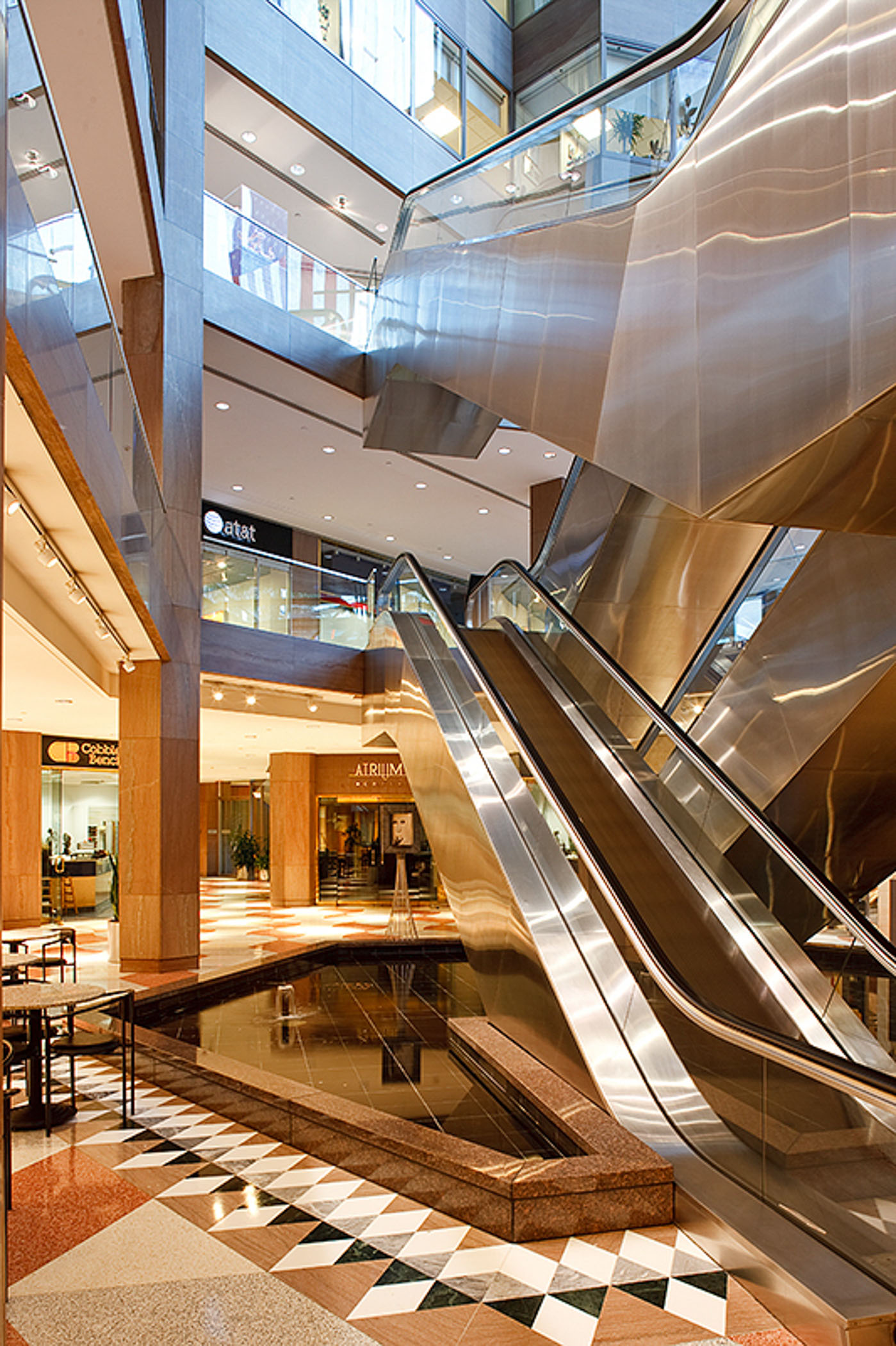 escalator with storefronts in the background of Washington Square